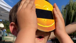 Enfant qui regarde le solei avec un équipement
