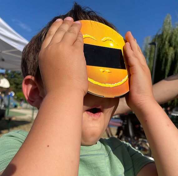 Enfant qui regarde le solei avec un équipement