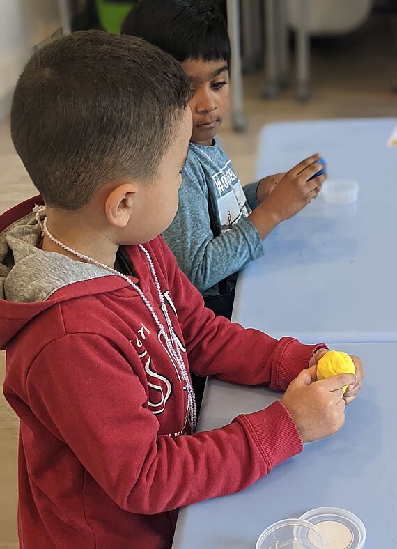 Garçon qui fait une boule avec de la pâte à modeler