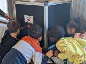 Élèves qui regardent dans une grande boîte noire